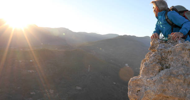 istock Mature man relaxes on mountain summit at sunset 1331603891