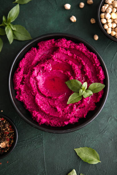 istock Hummus Bowl. Red beetroot hummus with fresh vegetables, olive oil on table 1331604530