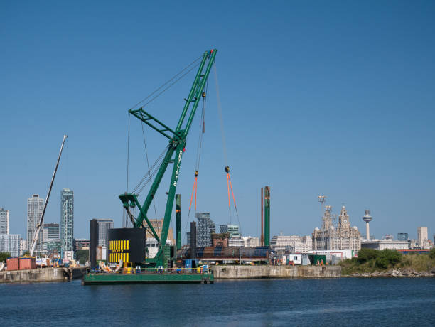 with the liverpool waterfront behind, the 250 tonne crane skylift 2 operating on the submersible skyline barge 26 while lifting equipment at docks in alfred dock, birkenhead - port alfred imagens e fotografias de stock