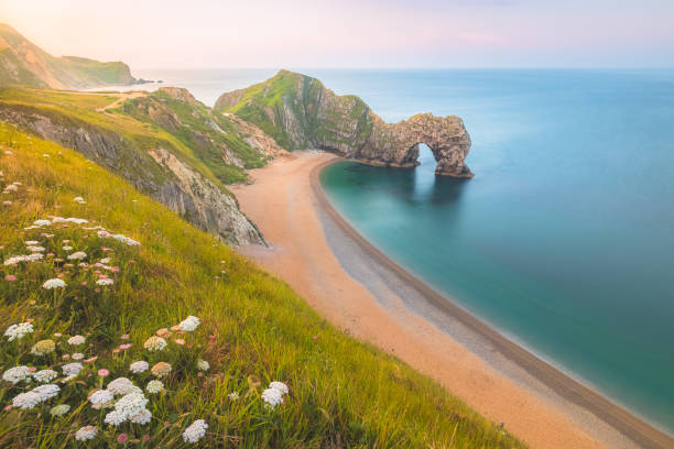 Durdle Door, Dorset The iconic landscape seascape rock formation sea arch Durdle Door at sunset or sunrise on the Jurassic Coast in Dorset, UK. dorset england stock pictures, royalty-free photos & images