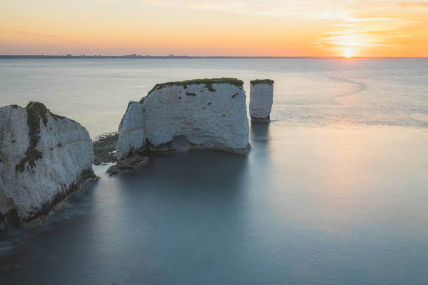 Old Harry Rocks. Dorset, England Colourful, idyllic sunset or sunrise sky over seascape landscape of the white chalk cliffs and sea stacks of Old Harry Rocks on the Jurassic Coast in Dorset, England, UK. old harry rocks stock pictures, royalty-free photos & images