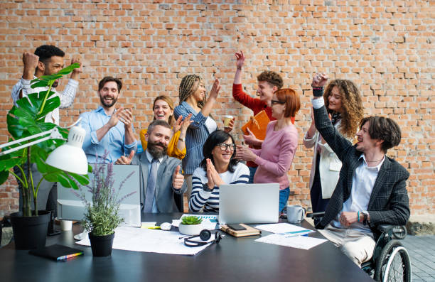 group of excited entrepreneurs working on project indoors in office, celebrating successful contract. - office fun group of people white collar worker imagens e fotografias de stock