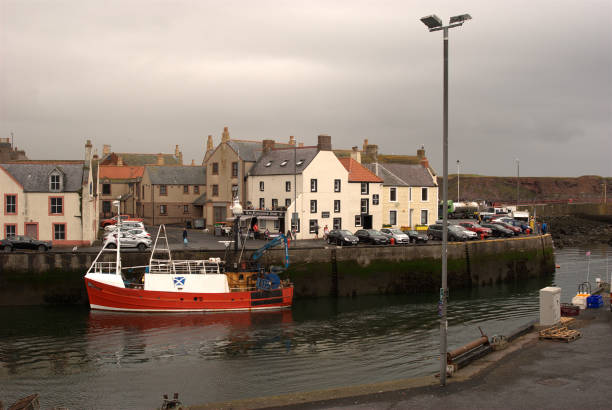 Eyemouth harbour fishing boat and town Berwickshire on dull day stock photo