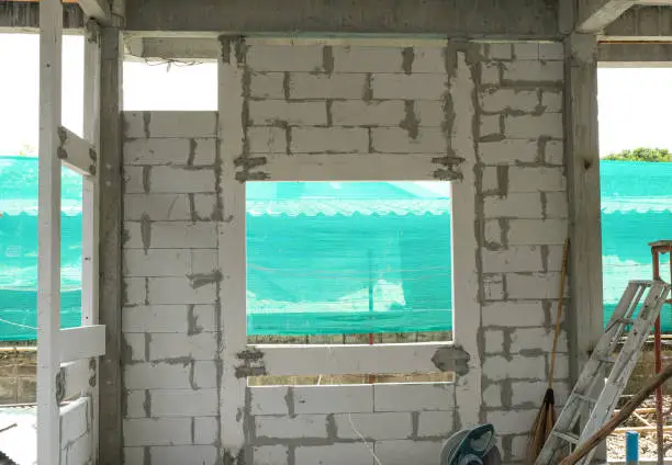 square windows lightweight cement brick and white lintel plaster to joint for reinforce widow house frame in construction site.