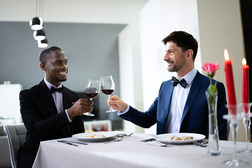 Gay Couple Having Dinner In Restaurant. People In Love