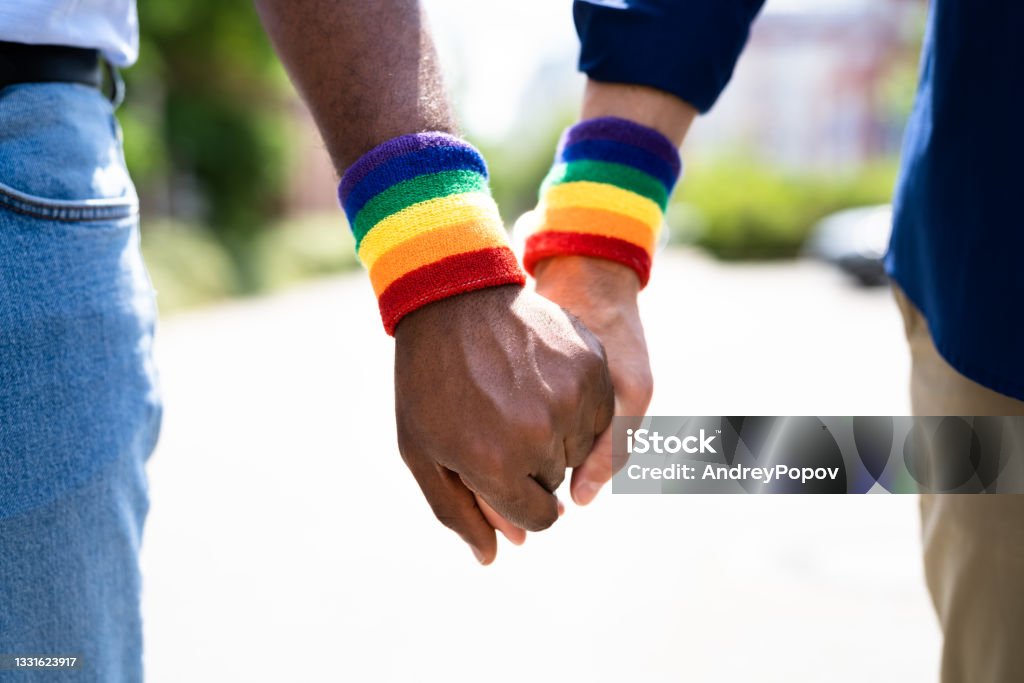 Gay Couple Holding Hands Gay Couple Holding Hands. LGBTQ Flag. LGBT Life Gay Couple Stock Photo