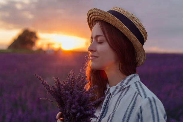 istock Young woman with lavender bouquet on sunset background 1331625341