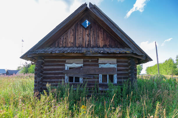 istock Old wooden rustic ruined abandoned house against a blue sky with white clouds on a bright summer sunny day. Close-up 1331625876