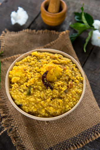 Khichdi or Khichadi, a popular Indian recipe. The food is made of dal or lentils and rice combined with Indian spices and tomatoes. Close up. Selective focus.