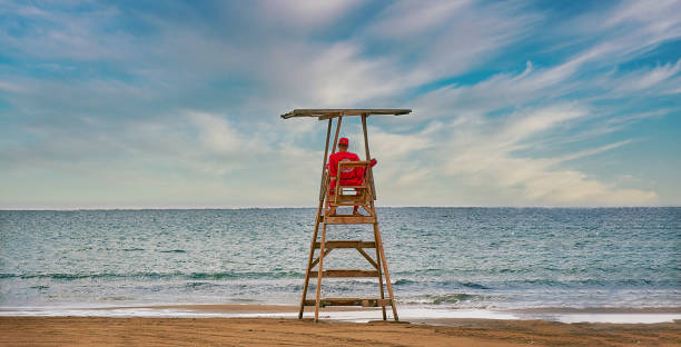 um salva-vidas vigiando uma praia solitária, devido às restrições do coronavírus e à falta de turistas. - lifeguard - fotografias e filmes do acervo