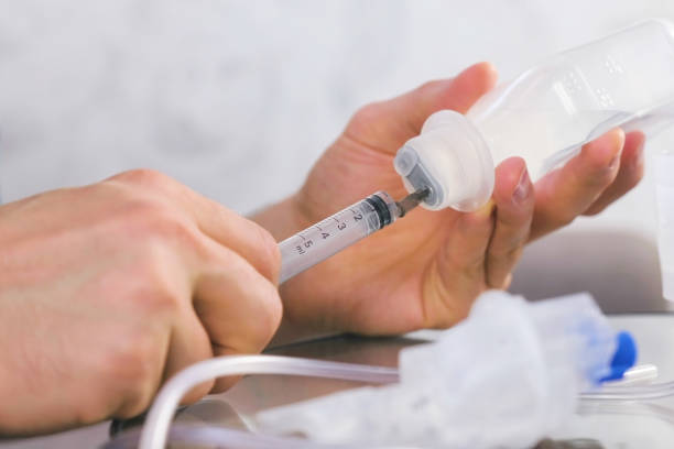 istock Man picking up the syringe with saline for inhalation. Hands close-up. 1331631892
