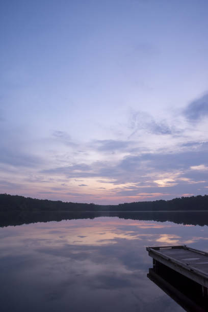 istock Pre-dawn clouds over calm lake with rustic pier 1331634415