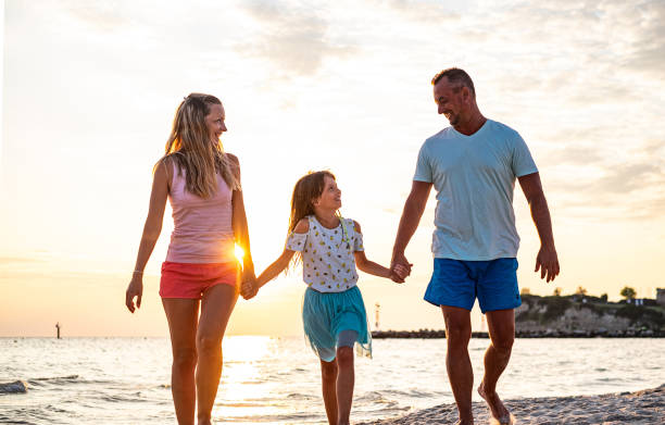 istock Happy family walking at the beach 1331635268