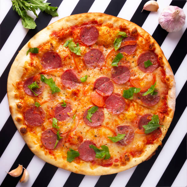 Pepperoni pizza with salami, mozzarella, tomatoes and rocket salad.
