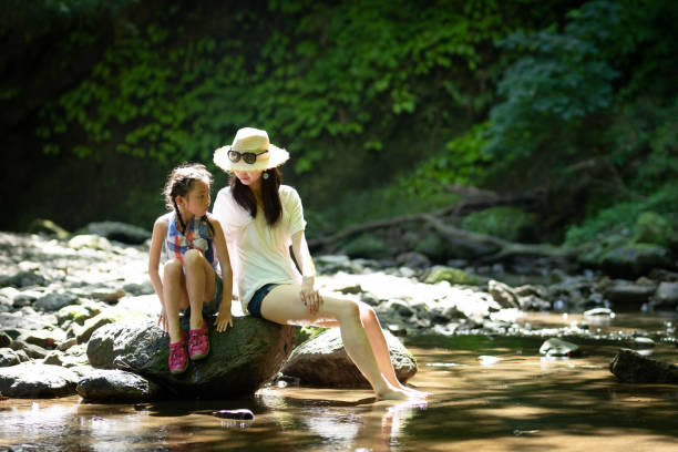 istock Mother and daughter playing in the mountain stream 1331636538