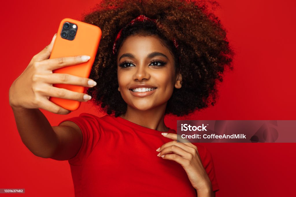 Pretty young afro woman holding a smart phone Selfie Stock Photo