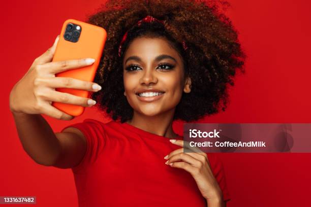 Pretty Young Afro Woman Holding A Smart Phone Stock Photo - Download Image Now - Selfie, African-American Ethnicity, African Ethnicity