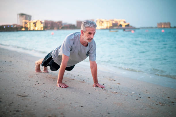 istock Senior man doing push-up exercises on the beach, sport abstract 1331640208