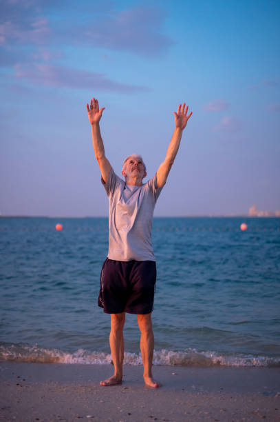 istock Senior man doing stretching exercises on the beach, sport abstract 1331640297