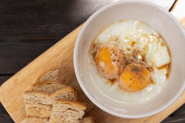 miękkie gotowane jajko z sosem przyprawowym i mielonym pieprzem z mini tostami na drewnianej tacy; widok z góry. - soft boiled zdjęcia i obrazy z banku zdjęć