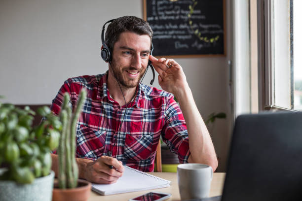 istock Man working from home in conference call with colleagues using headset 1331650280