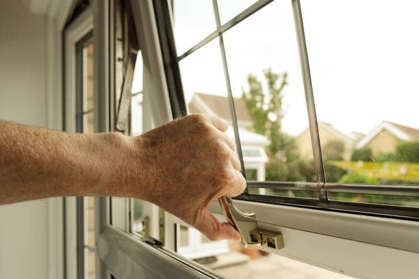 Homeowner seen about to lock a double glazed window seen on the ground level of a property. The latch can itself be locked to enhance security. hinge stock pictures, royalty-free photos & images