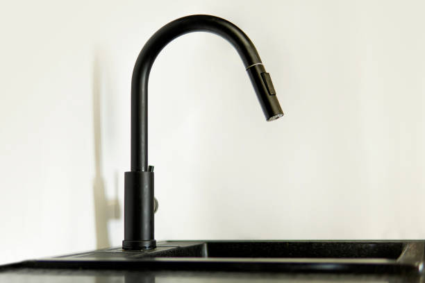istock Black mixer tap with flowing water on white background 1331653379