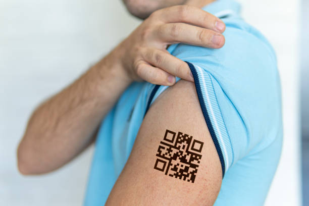 mann zeigt seine schulter mit einem qr-code, einer bestätigung der impfung gegen das covid-19-coronavirus. temporäre tätowierung. - tattoo men human arm shoulder stock-fotos und bilder