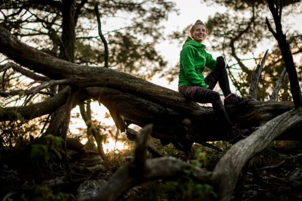 istock young athletic woman sits on fallen tree on background of trees in forest 1331656401