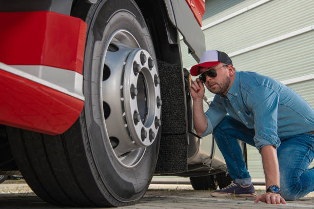 istock Trucker Looking on Semi Truck Wheel 1331658225