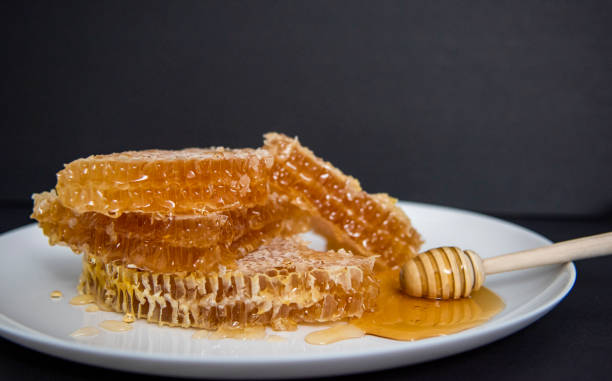 istock Honeycomb and bamboo dipper on plate 1331661418