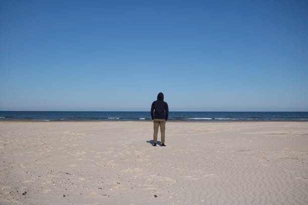 istock young man standing on the beach 1331667877
