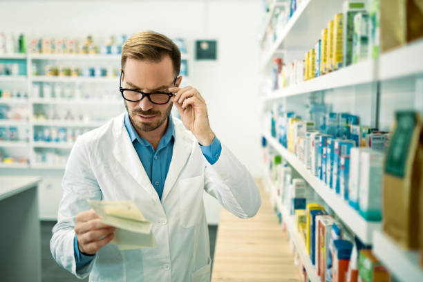 istock Pharmacist checking inventory at pharmacy holding prescription recipes 1331674254