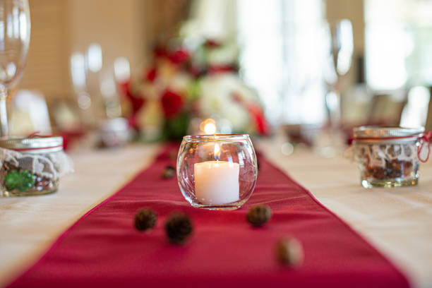 istock Glass candle holder with white lit candle centerpiece on red table cloth wedding reception 1331675211