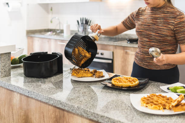 frau serviert gebratenes huhn mit fritteusewaffeln - waffle syrup pouring breakfast stock-fotos und bilder
