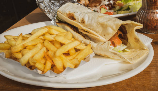 Kebab and French fries recipe on a white dish table in an European country. stock photo