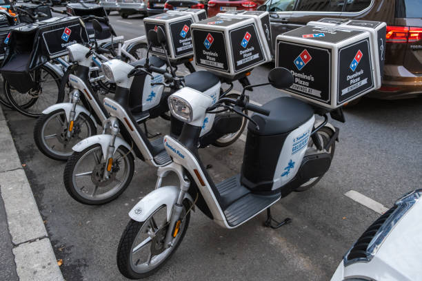 vista di domino pizza, una catena multinazionale americana di ristoranti pizzeria, veicolo scooter di consegna per strada a vieanna, austria. - dominos pizza foto e immagini stock