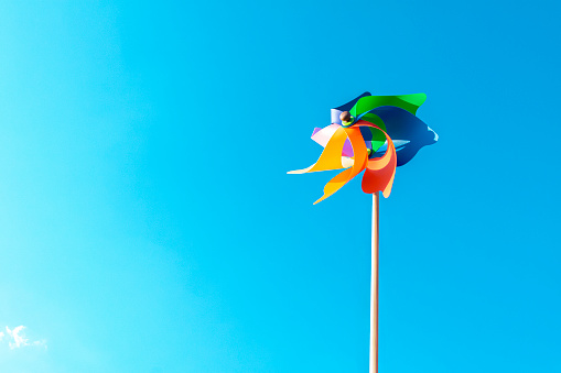Multicolored Toy Weather Vane, WindMill With Clean Blue Sky, Copy space