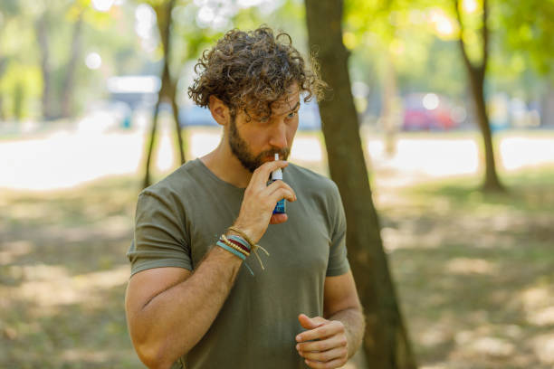 istock Young Bearded Man with Sinusitis is Using Nasal Spray in a Park. 1331686538