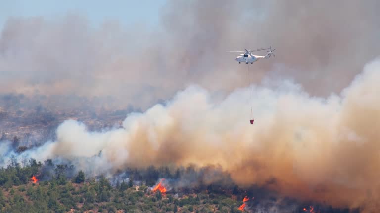 Firefighting helicopter rescue Aircraft in action dropping water over flames