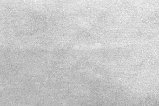 Photo of Silver white velvet background or velour flannel texture made of cotton or wool with soft fluffy velvety satin fabric cloth metallic color material