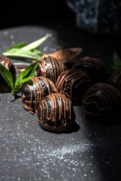 istock Chocolate truffles. Dark chocolate candies with cocoa on a dark background 1331698848