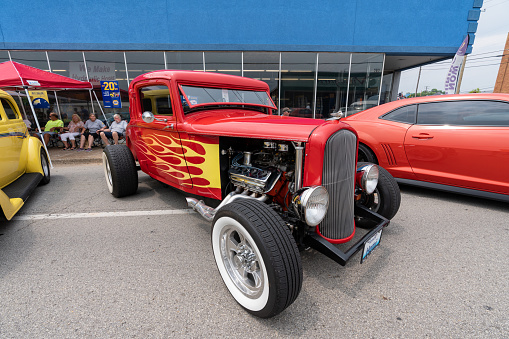 Elizabethtown, KY, USA - July 31, 2021: Red classic hotrod with yellow flames on display during the Cruisin' The Heartland 2021 car show in downtown Elizabethtown, KY.