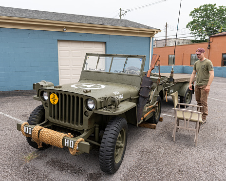 Elizabethtown, KY, USA - July 31, 2021: Classic Jeep painted olive drab with military markings on display during the Cruisin' The Heartland 2021 car show in downtown Elizabethtown, KY.
