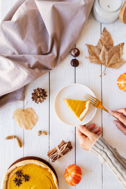 istock Homemade pumpkin pie with autumn leaves on rustic background, top view 1331719631