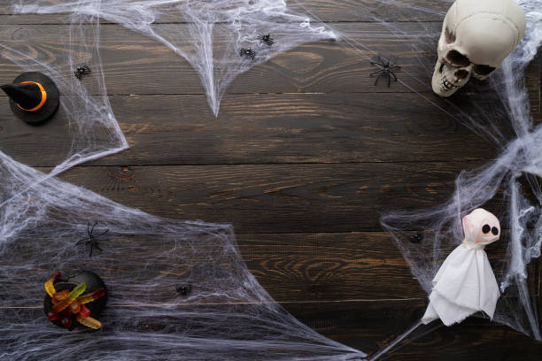 istock Halloween holiday background with spider web and scary decorations on black wooden backdrop 1331721291