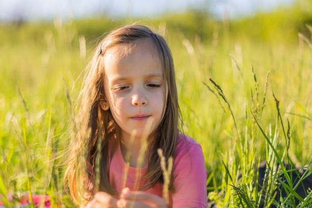 Close-up of cute little girl playing in the meadow during sunny day