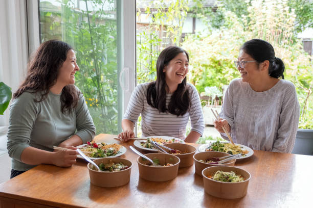 istock Multi-Ethnic Daughters, Asian Mother Laughing and Eating Vegan Takeout Dinner 1331732585
