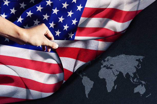 istock Hand holding an American flag with world map 1331733689