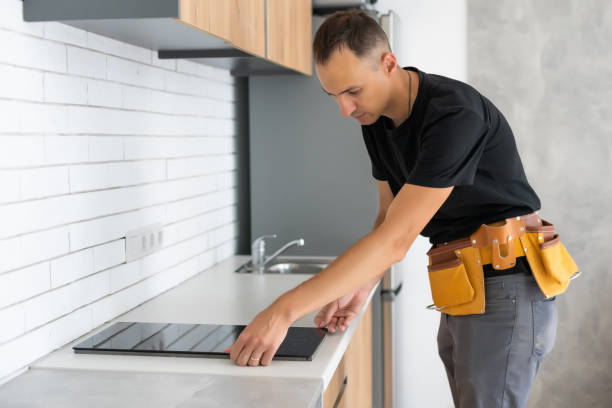 istock Young Repairman Installing Induction Cooker In Kitchen 1331734965